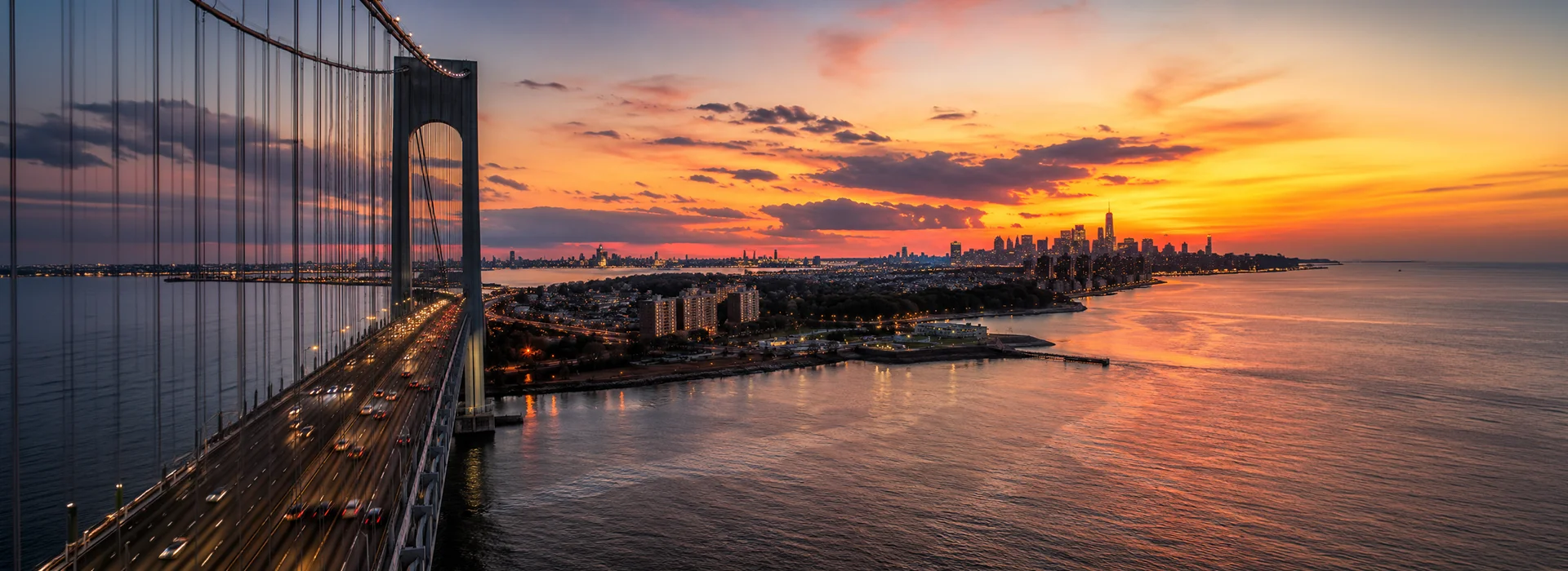 Panoramic view from the Verrazzano-Narrows Bridge toward the New York City skyline at sunset