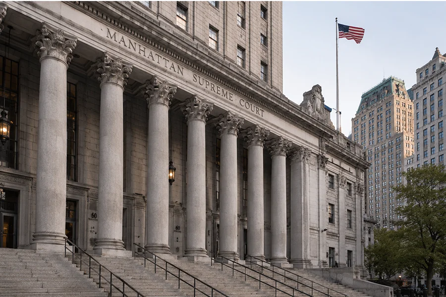 Stone columns and steps of the Manhattan Supreme Court with the American flag